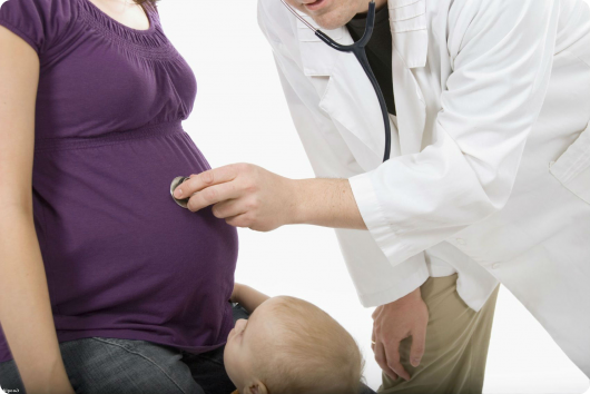 врач осматривает беременную девушку