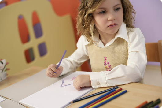 ребенок рисует цветными карандашами