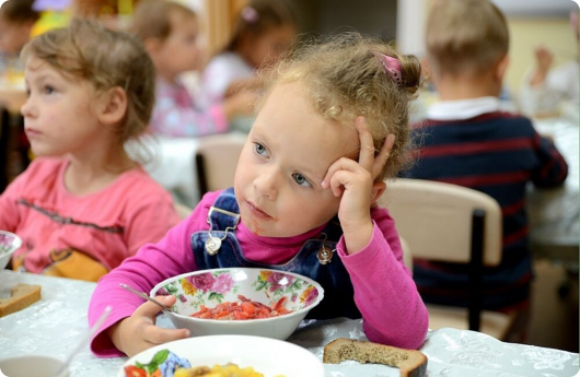 девочка в детском садике кушает суп